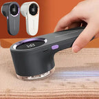 Fabric shaver removing bobbles from a knitted jumper